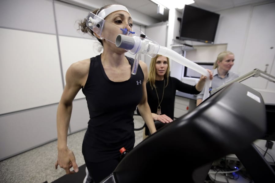 Research scientist Leila Walker, left, is assisted by nutritional physiologist Holly McClung, center, in April as they demonstrate equipment designed to evaluate fitness levels in female soldiers, not shown, who have joined elite fighting units such the Navy Seals, at the U.S. Army Research Institute of Environmental Medicine, at the U.S. Army Combat Capabilities Development Command Soldier Center, in Natick, Mass.