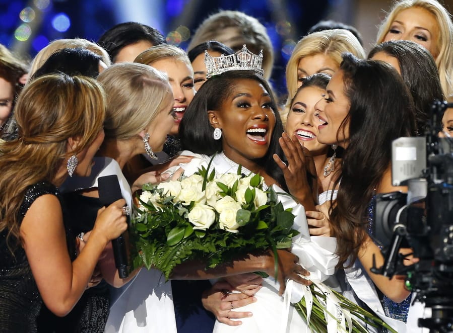 FILE - This Sept. 9, 2018 file photo shows Miss New York Nia Franklin, center, reacting after being named Miss America 2019 in Atlantic City, N.J. The Miss America Organization says this year’s pageant will be held at the Mohegan Sun Connecticut in Uncasville, Connecticut. It will be broadcast on NBC Dec. 19, in a switch from recent broadcaster ABC. (AP Photo/Noah K.