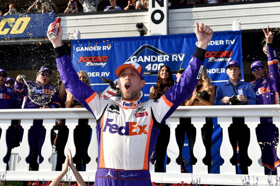 Denny Hamlin celebrates in Victory Lane after winning a NASCAR Cup Series auto race, Sunday, July 28, 2019, in Long Pond, Pa.