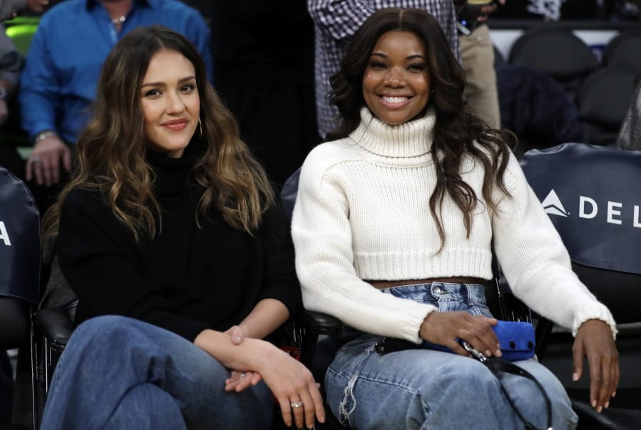 FILE - This Dec. 10, 2018 file photo shows actresses Jessica Alba, left, and Gabrielle Union at an NBA basketball game between the Los Angeles Lakers and the Miami Heat in Los Angeles.
