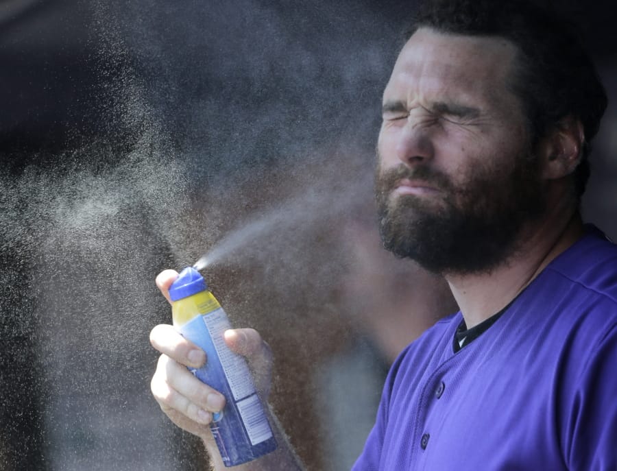 Colorado Rockies’ Daniel Murphy applies sunscreen before a baseball game against the New York Yankees at Yankee Stadium, Sunday, July 21, 2019, in New York.