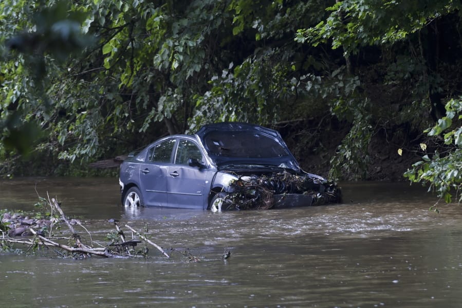 Receding floodwaters of the Manatawny Creek in Boyertown, Pa., Friday, July 12, 2019, reveal the vehicle in which a pregnant woman and young son drowned Thursday after their car was swept from Grist Mill Road in Douglass Township. Emergency workers found the car in a tributary nearly five hours later. The bodies of woman and child were removed on stretchers Thursday, but the car remained in the creek Friday morning. The names of the woman and her son have not been released.