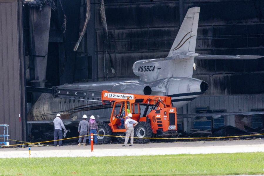 National Transportation Safety Board investigators and others inspect a hangar at Addison Airport in Addison, Texas, Monday, July 1, 2019, the day after a twin-engine plane crashed into the building killing all ten people on board.