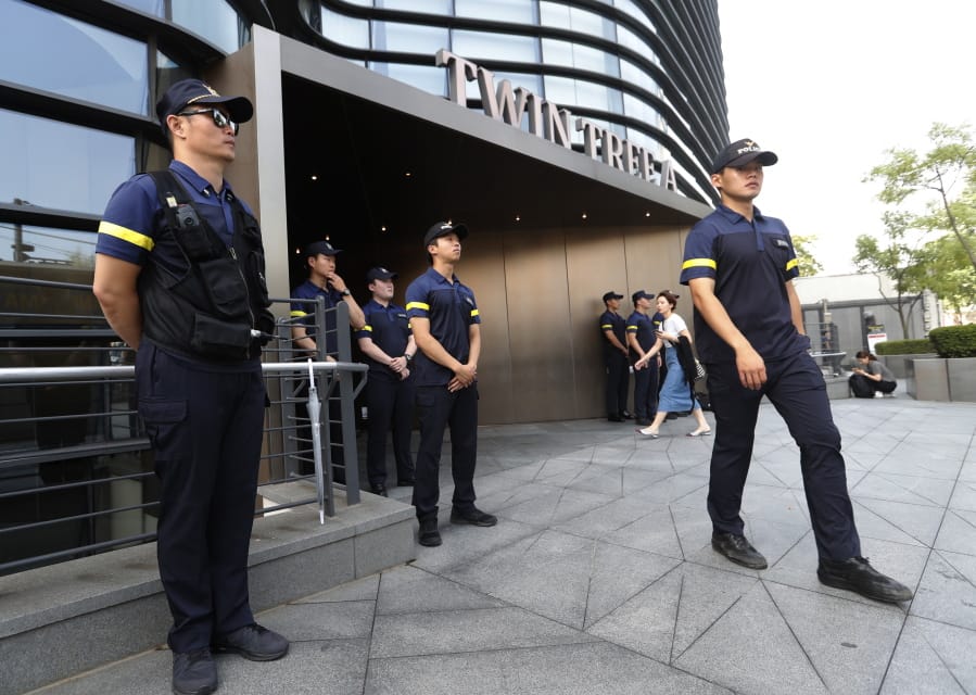 South Korean police officers stand guard against possible rallies against Japan in front of a building where the Japanese embassy is located in Seoul, South Korea, Friday, July 19, 2019. South Korean police say a man has set himself on fire in front of the Japanese Embassy in Seoul amid rising trade disputes between Seoul and Tokyo.