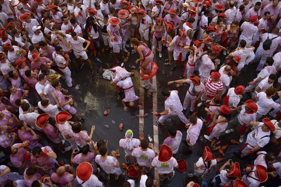 Revellers celebrate while waiting for the launch of the 'Chupinazo' rocket, to celebrate the official opening of the 2019 San Fermin fiestas with daily bull runs, bullfights, music and dancing in Pamplona, Spain, Saturday July 6, 2019.