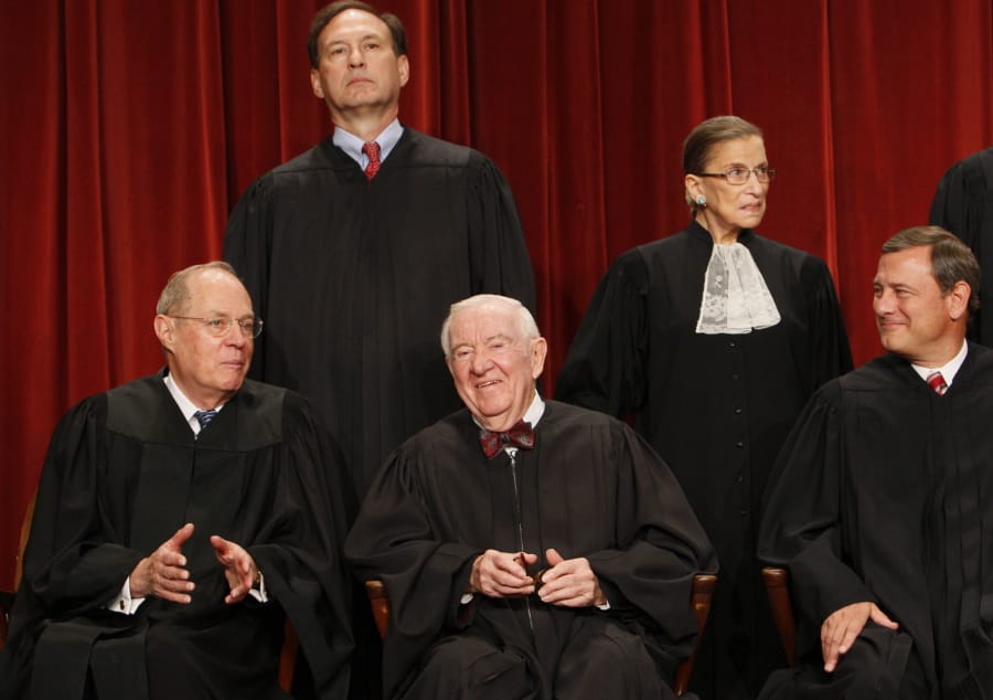 FILE - In this Sept. 29, 2009 file photo Associate Justice John Paul Stevens, center, sits for a group photograph at the Supreme Court in Washington. Stevens, the bow-tied, independent-thinking, Republican-nominated justice who unexpectedly emerged as the Supreme Court’s leading liberal, died Tuesday, July 16, 2019, in Fort Lauderdale, Fla., after suffering a stroke Monday. He was 99.
