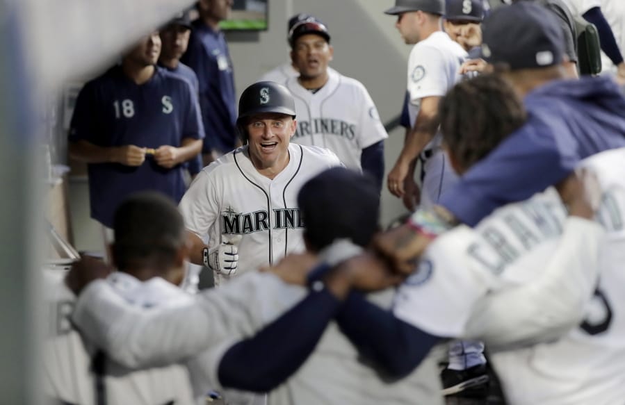Teammates stand arm-in-arm as they wait to celebrate with Seattle Mariners’ Kyle Seager, center, after Seager hit a solo home run against the Detroit Tigers during the fifth inning of a baseball game, Thursday, July 25, 2019, in Seattle. (AP Photo/Ted S.
