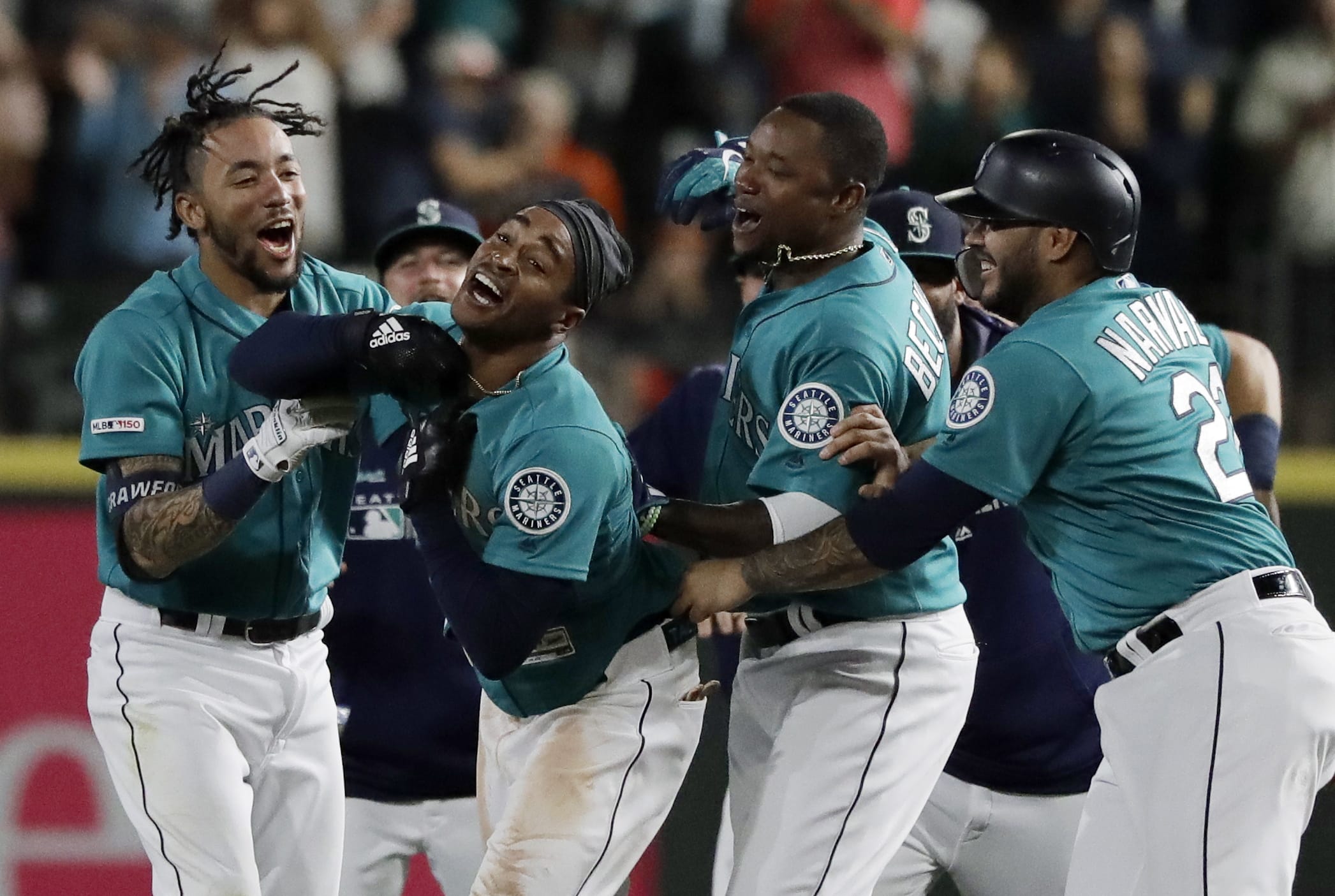 Seattle Mariners' Mallex Smith, second from left, is mobbed by teammates, including J.P. Crawford, left, Tim Beckham, second from right, and Omar Narvaez, right, after Smith hit a walk-off RBI single in the ninth inning of a baseball game against the Detroit Tigers to score Kyle Seager and give the Mariners a 3-2 win, Friday, July 26, 2019, in Seattle. (AP Photo/Ted S.