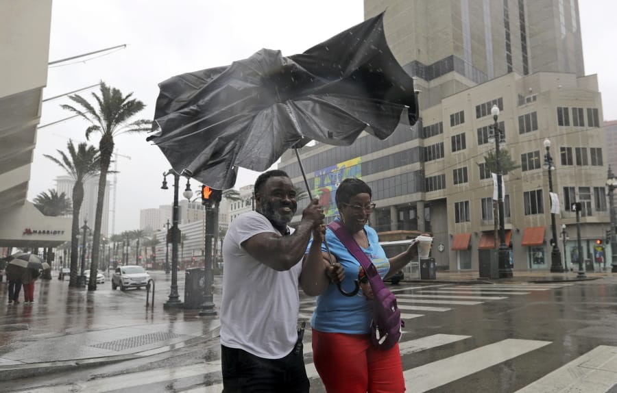 Karon Hill, left, and Celeste Cruz battle the wind and rain from Barry as it nears landfall Saturday in New Orleans. david j.