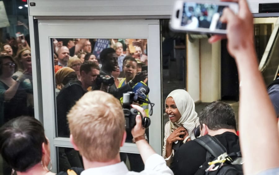 U.S. Rep. Ilhan Omar reacts as she’s greeted by supporters cheering “Welcome Home Ilhan!” as she arrived home at Minneapolis–Saint Paul International Airport, Thursday, July 18, 2019, in Minnesota. President Donald Trump is chiding campaign supporters who’d chanted “send her back” about Somali-born Omar, whose loyalty he’s challenged.
