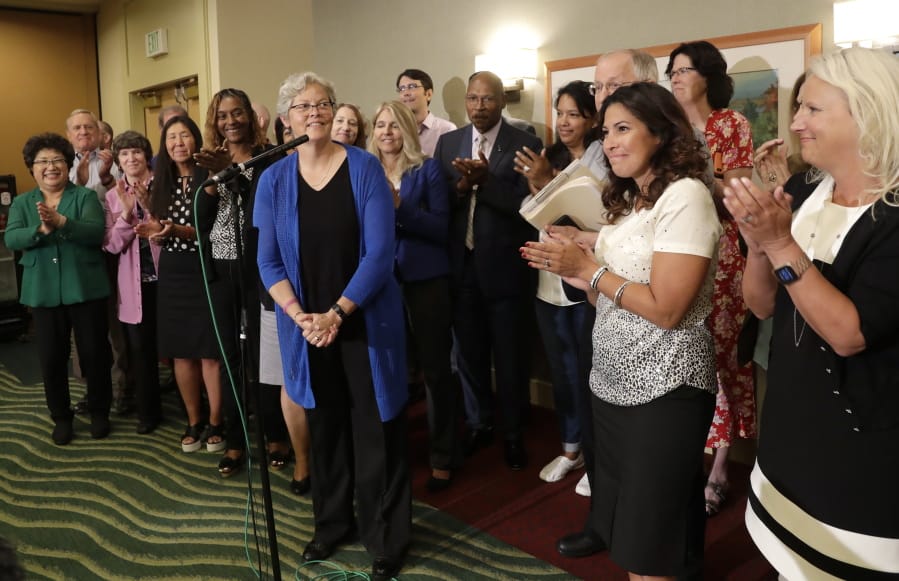 State Rep. Monica Stonier, D-Vancouver, second from right, applauds after Rep. Laurie Jinkins, in blue, was introduced at a news conference following a vote by Democrats choosing Jinkins as speaker of the House. Stonier was one of four female representatives seeking the top spot.