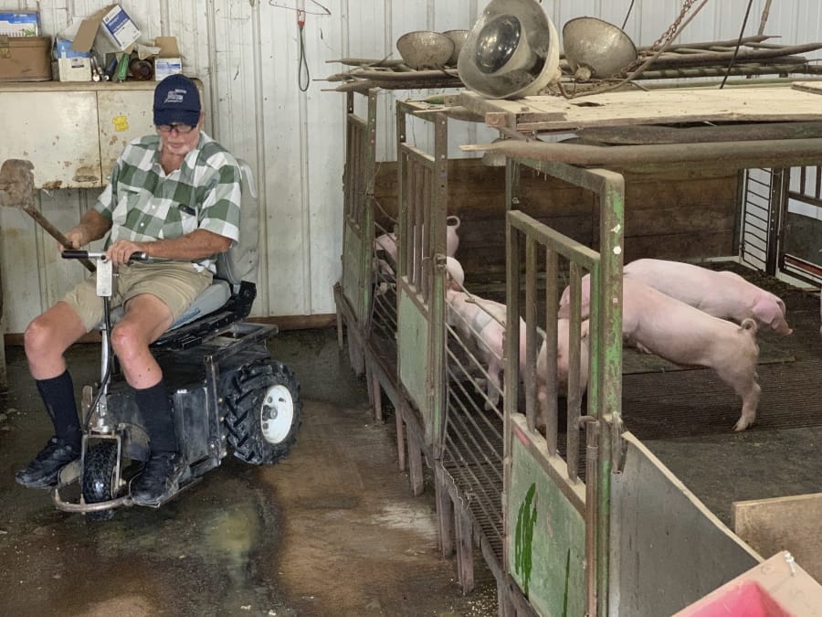 Farmer Mark Hosier, 58, rides a scooter July 10 as he checks on his pigs on his farm in Alexandria, Ind. Hosier was injured in 2006 when a 2,000-pound bale of hay fell on him while he was working.