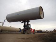 A finished section of pipe is moved by a forklift at a Northwest Pipe Company in Pleasant Grove in February 2011. The pipe was slated to eventually cover the Murdock Canal.