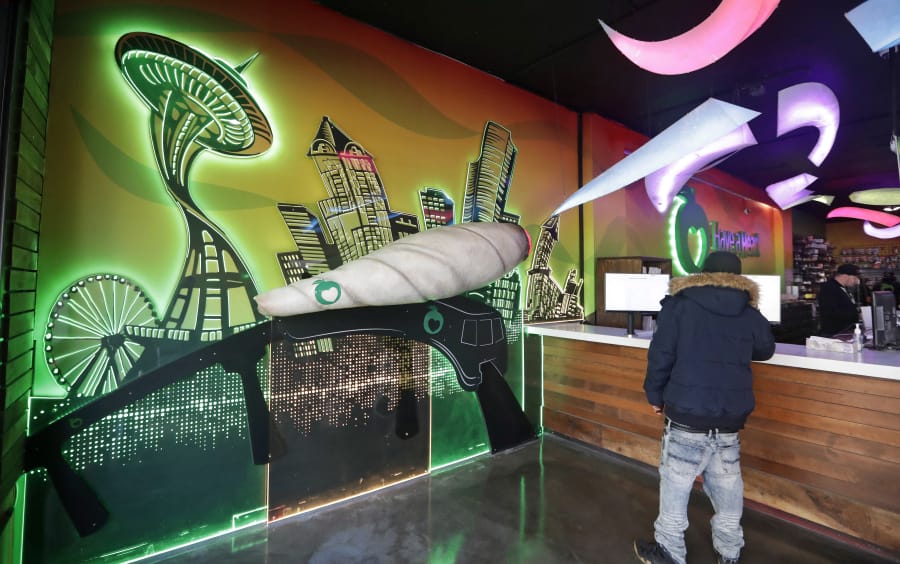 A stylized rendering of the city’s skyline, including an oversized pot blunt, greets customers at a marijuana shop in Seattle in March. A study by the Pew Charitable Trusts warns states with legal cannabis markets to be careful with how they use tax money generated by marijuana.