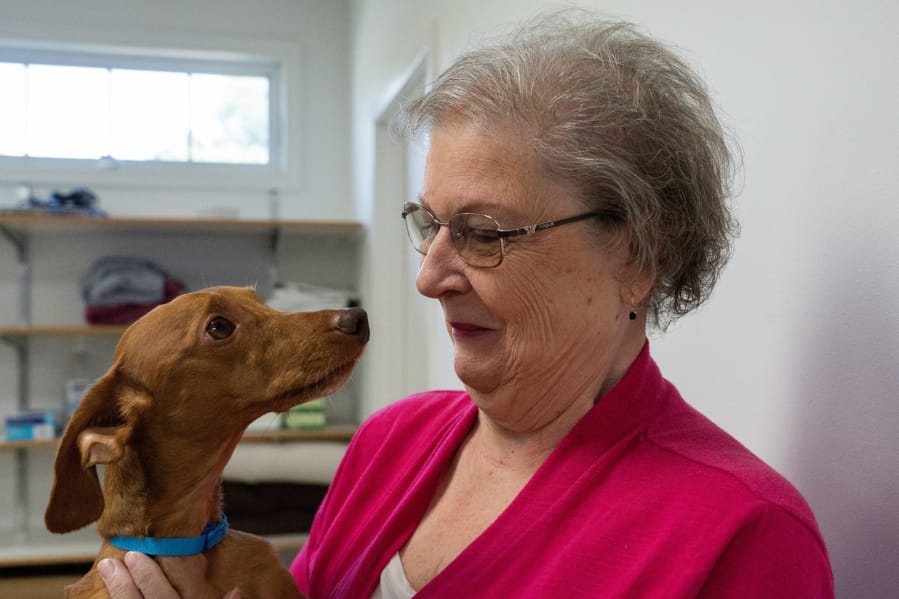 Lorraine Young hugs her dog, Andy, on a visit Aug. 12 to the vet after the dog received emergency spine surgery in July and is now almost fully recovered at St. Francis Veterinary Center in Swedesboro, N.J.
