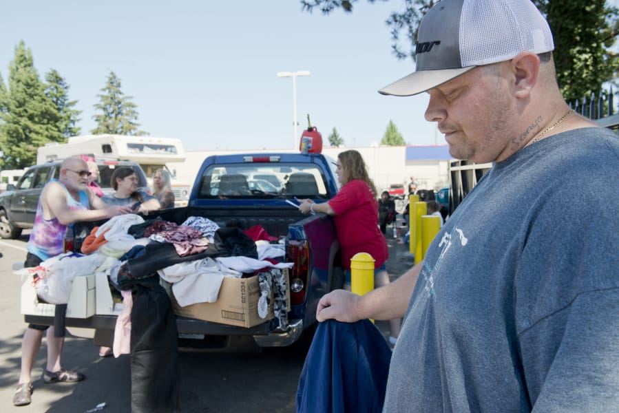 Vancouver resident Charles Hanset, at right, who marked two years of sobriety in June, volunteers by donating clothes and food to the homeless at the Vancouver Navigation Center, a homeless resource center.