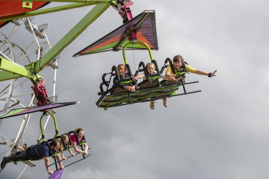 Amelia Canterbury, 9, of Vancouver, left, flies on the Cliff Hanger.