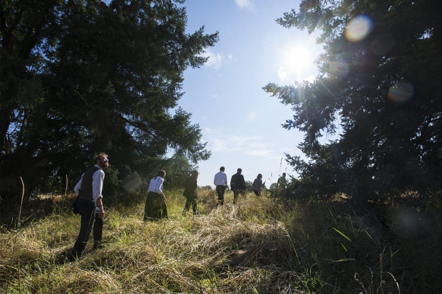 Jonathan Young, interim Vancouver city attorney, left, examines the treeline at the Fenton property on Monday evening during a Vancouver City Council mobile workshop.