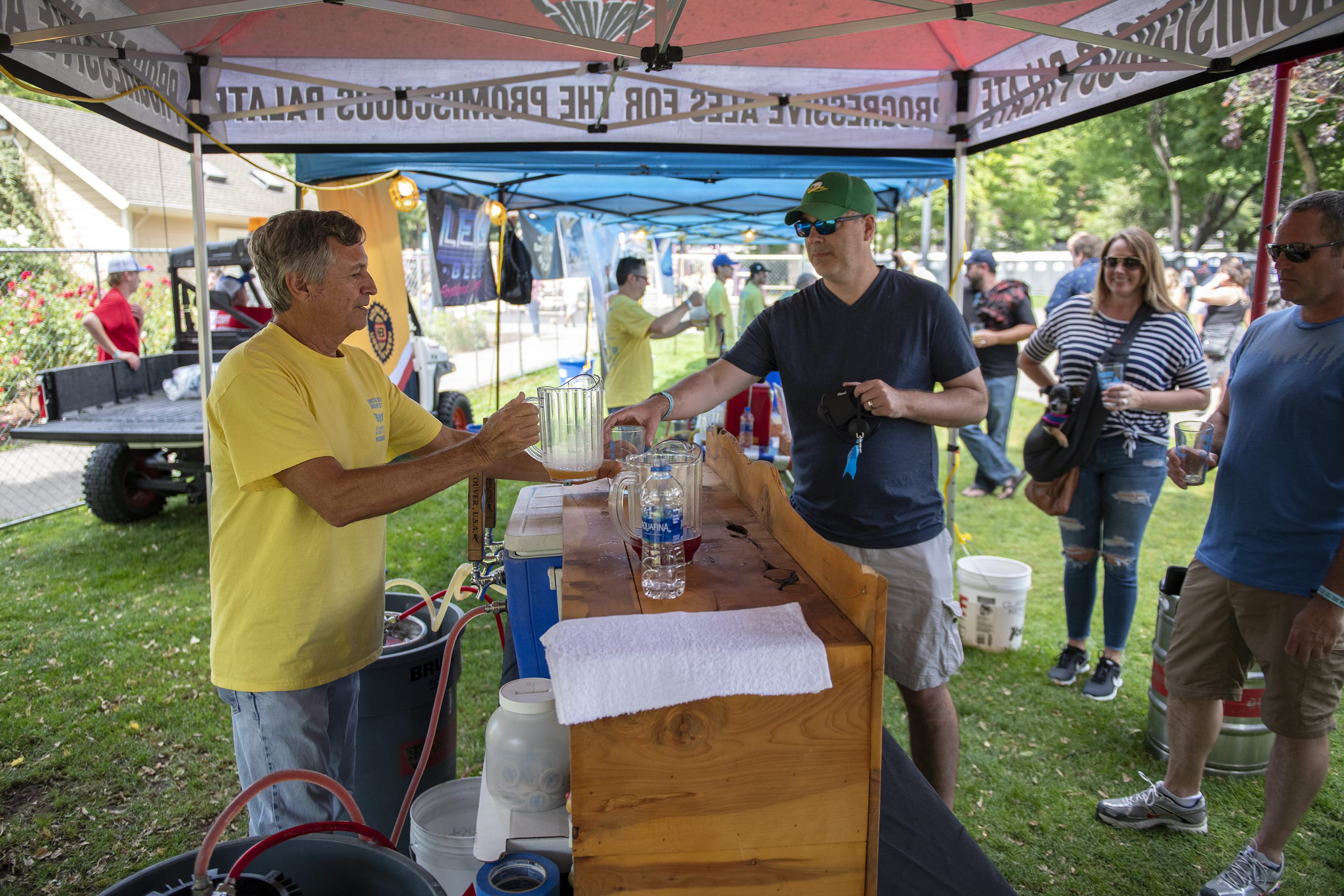 Volunteer Peter Brubaker, left, pours a beer for Mitch Staples of Felida at Vancouver Brewfest in Esther Short Park on Saturday afternoon, August 10, 2019.