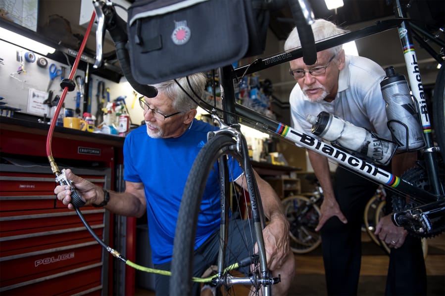 Brothers Mark Roskam, left, and Mike Roskam perform maintenance on Mark’s bike at Wheel Deals Bicycles on Monday. The two plan to ride Route 66 starting next month for a fundraiser.