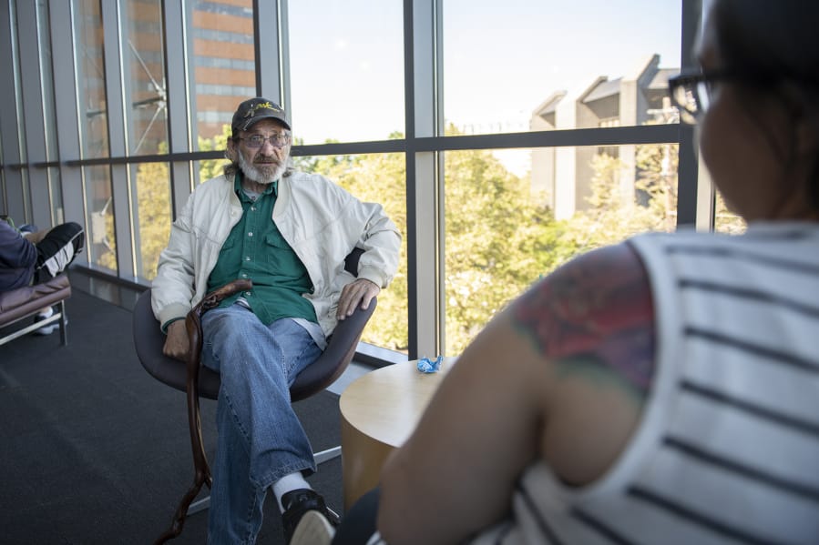 Jack Crowley of Battle Ground speaks with Community Services Northwest case manager Jamie Spinelli at the Vancouver Community Library. Spinelli recently helped Crowley find an apartment after he had been homeless for many years.