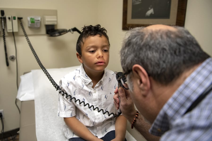 Grant Raymond, 7, waits as Dr. Dino Ramzi examines him during a physical at Delta Direct Care in Battle Ground. Delta Direct Care has undergone rebranding, changing its name from Patient Direct Care. Delta Direct has plans to open a Vancouver clinic in early 2020.