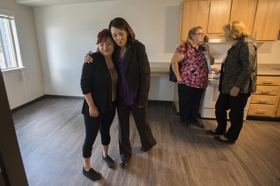 Christina LaCelle, a future Caples Terrace resident, from left, gets a hug from U.S. Sen. Maria Cantwell as they tour the new 28-unit apartment building with Dena Horton, Cantwell’s Southwest Washington outreach director, and Vancouver Mayor Anne McEnerny-Ogle on Monday morning. LaCelle said she was looking forward to enjoying her future home with her baby daughter.