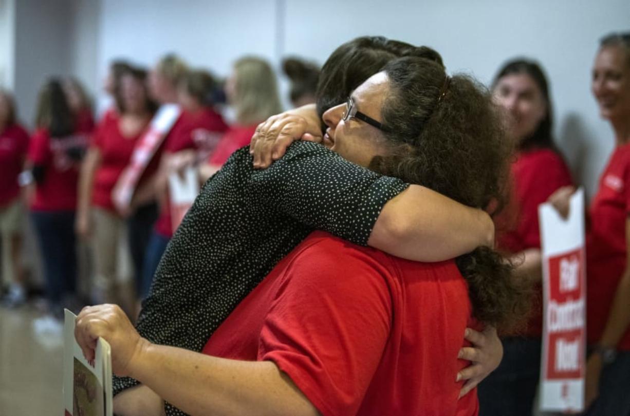 La Center graduate Andrea Lewis, right, embraces La Center English teacher Karen Gozart as the teachers lined up before a morning bargaining session with the district at La Center High School on Aug. 20.