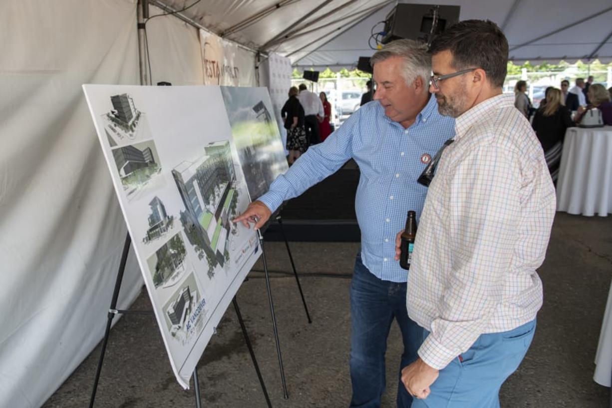 Rob Gartner, vice president of business development for Vesta Hospitality, left, describes the future AC Hotel layout to David Partridge of Vancouver during the ceremonial groundbreaking on Thursday afternoon. At top, a concept art rendering shows the future AC Hotel by Marriott, which broke ground today at Terminal 1.