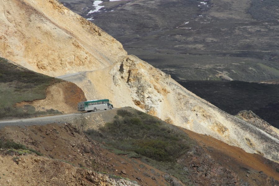This May 27, 2016, photo shows a tourist bus near Polychome Pass on the only road inside Denali National Park and Preserve, Alaska. Park officials on Friday, Aug. 16, 2019, closed the park road at Mile 30 of the 92-mile road after a culvert washout and several mudslides in the area surrounding Polychome Pass and Eielson Visitor Center created unsafe conditions.