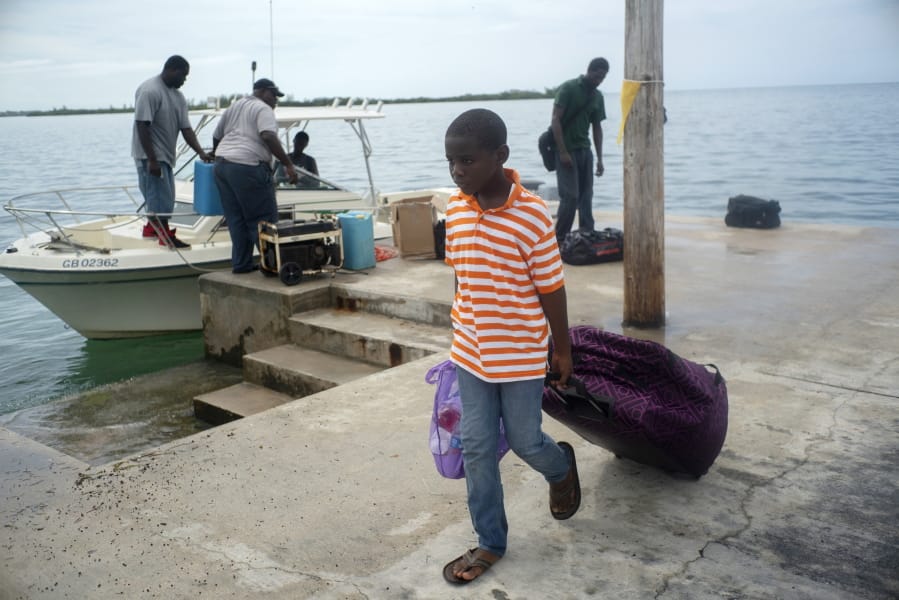 A child evacuated from a nearby Cay due to the danger of floods drags his suitcase when he arrives on a ship at the port before the arrival of Hurricane Dorian in Sweeting’s Cay, Grand Bahama, Bahamas, Saturday Aug. 31, 2019. Dorian bore down on the Bahamas as a fierce Category 4 storm Saturday, with new projections showing it curving upward enough to potentially spare Florida a direct hit but still threatening parts of the Southeast U.S. with powerful winds and rising ocean water that causes what can be deadly flooding.