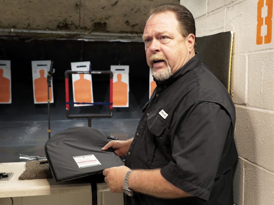 Steve Naremore, founder and CEO of TuffyPacks, handles one of his bulletproof panels that can be inserted into various makes and sizes of backpacks before a shooting demonstration of the stopping ability of the product at the Shiloh Shooting Range, Friday, August 9, 2019, in Houston. His company produces some bullet-resistant backpacks but the bulk of his business is in removable ballistic shields that are inserted in backpacks.