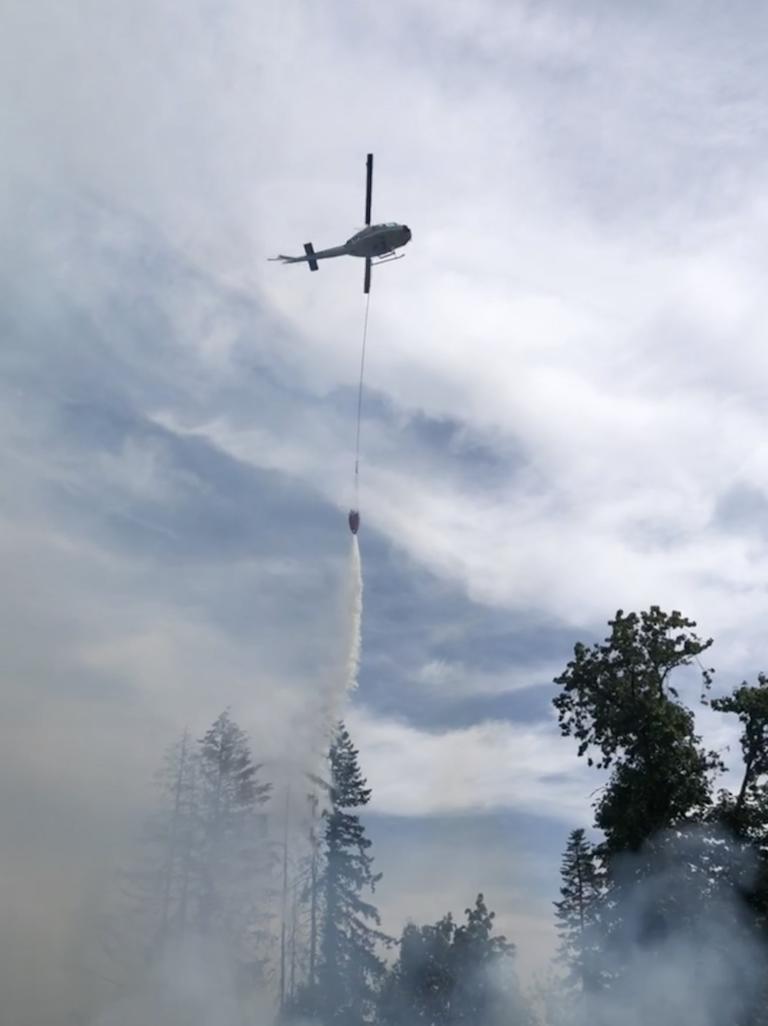 A state Department of Natural Resources helicopter drops water over a brush fire Tuesday afternoon on the 2500 block of Northeast 179th Street (Clark County Fire & Rescue).