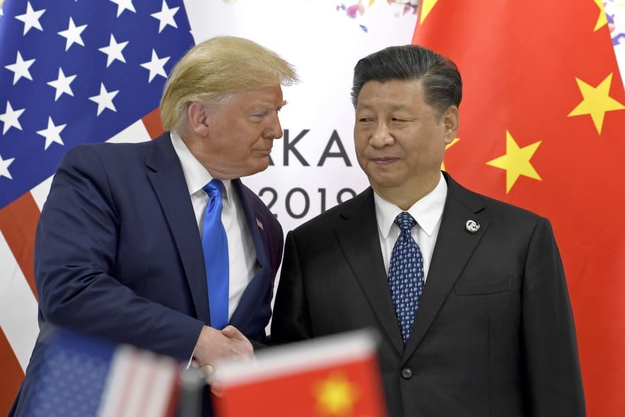 FILE - In this June 29, 2019, file photo, U.S. President Donald Trump, left, shakes hands with Chinese President Xi Jinping during a meeting on the sidelines of the G-20 summit in Osaka, western Japan. Facing another U.S. tariff hike, Xi is getting tougher with Washington instead of backing down. Both sides have incentives to settle a trade war that is battering exporters on either side of the Pacific and threatening to tip the global economy into recession.