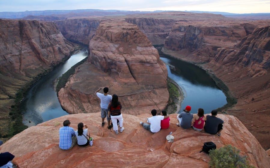 FILE - In this Sept. 9, 2011 file photo visitors view the dramatic bend in the Colorado River at the popular Horseshoe Bend in Glen Canyon National Recreation Area, in Page, Ariz. Some 40 million people in Arizona, California, Colorado, Nevada, New Mexico, Utah and Wyoming draw from the Colorado River and its tributaries. Much of that originates as snow. A wet winter likely will fend off mandated water shortages for states in the U.S. West that rely on the river but won’t erase the impact of climate change. Climate change means the region is still getting drier and hotter. (AP Photo/Ross D.