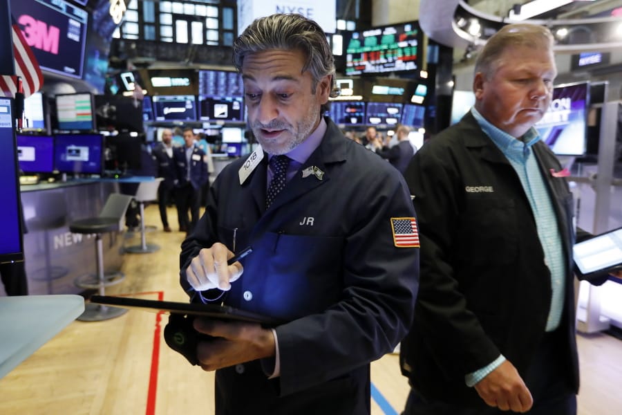 Traders John Romolo, left, and George Ettinger work on the floor of the New York Stock Exchange, Friday, Aug. 16, 2019. Stocks are opening broadly higher at the end of a turbulent week.