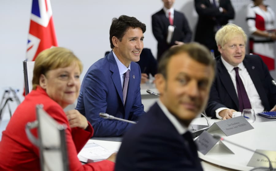 Canadian Prime Minister Justin Trudeau, second from left, German Chancellor Angela Merkel, left, President of France Emmanuel Macron, second from right, and British Prime Minister Boris Johnson take part in a working session with G7 leaders on the second day of the G-7 summit in Biarritz, France Sunday, Aug. 25, 2019.