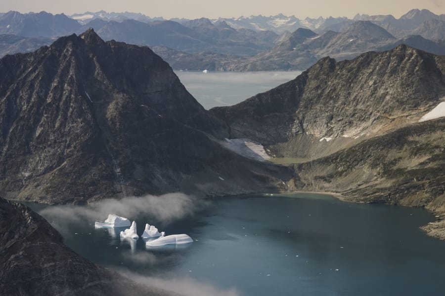 In this photo taken on Wednesday, Aug. 14, 2019, icebergs are photographed from the window of an airplane carrying NASA Scientists as they fly on a mission to track melting ice in eastern Greenland. Greenland has been melting faster in the last decade and this summer, it has seen two of the biggest melts on record since 2012.