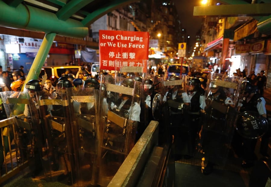 Police move out from the Shum Shui Po police station to confront protesters in Hong Kong on Wednesday, Aug. 14, 2019.