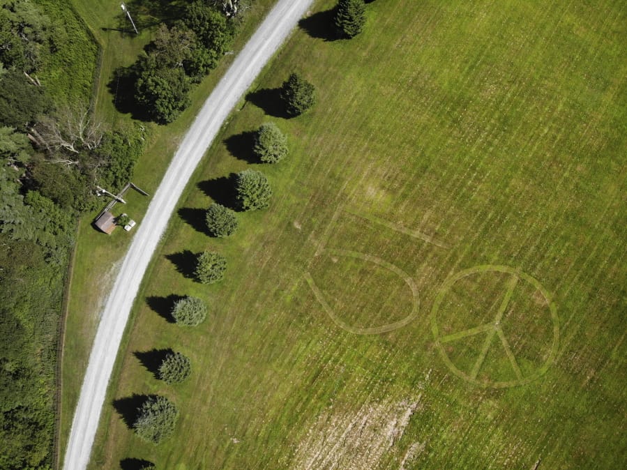 This Wednesday, July 24, 2019, photo shows the number 50 and a peace sign mowed into the grass at the site of the 1969 Woodstock Music and Arts Fair in Bethel, N.Y. Fifty years later, memories of the rainy weekend Aug. 15-18, 1969, remain sharp among people who were in the crowd and on the stage.