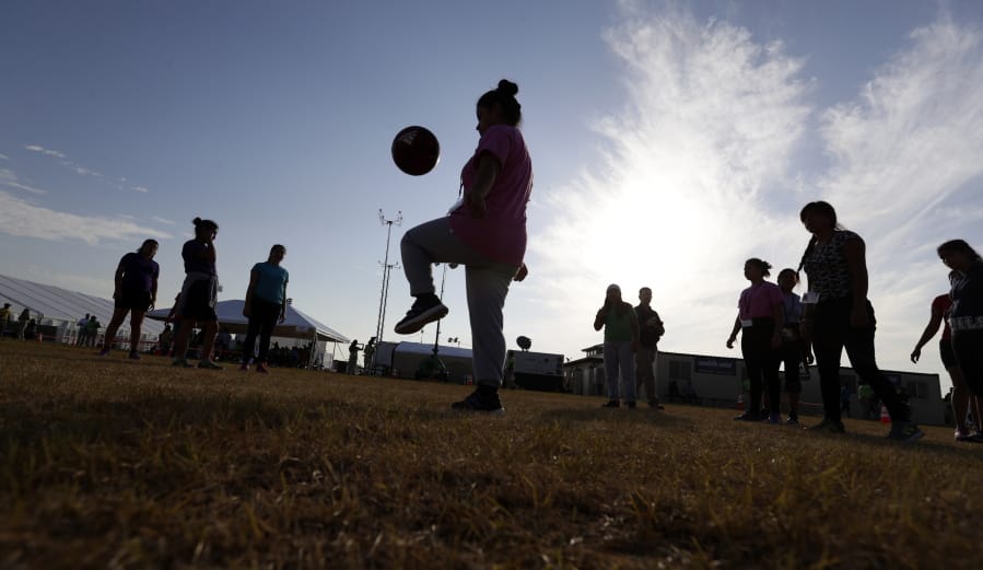 File - In this July 9, 2019, file photo, immigrants play soccer at the U.S. government’s newest holding center for migrant children in Carrizo Springs, Texas. A panel of judges has dismissed an appeal by the U.S. government that contended detained immigrant children might necessarily require soap for shorter stints in custody under a longstanding settlement agreement. A three-judge panel for the Ninth U.S. Circuit Court of Appeals in San Francisco on Thursday, Aug. 15, 2019, dismissed a challenge to a lower court decision that authorities failed to provide safe and sanitary conditions for the children under the 1997 settlement.