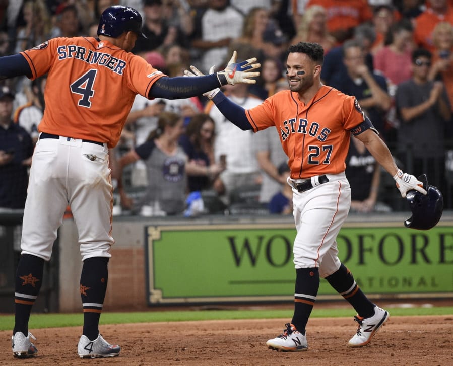 Houston Astros’ Jose Altuve (27) celebrates his solo home run off Seattle Mariners starting pitcher Yusei Kikuchi with George Springer during the fourth inning of a baseball game Friday, Aug. 2, 2019, in Houston.