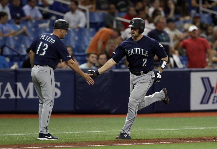 Seattle Mariners’ Tom Murphy (2) shakes hands with third base coach Chris Prieto (13) after Murphy hit a two-run home run off Tampa Bay Rays relief pitcher Jalen Beeks during the sixth inning of a baseball game Tuesday, Aug. 20, 2019, in St. Petersburg, Fla.