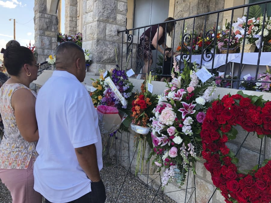 Mourners deliver flowers on Friday, Aug. 16, 2019, for the funeral in El Paso, Texas, of Margie Reckard, 63, who was killed by a gunman in a mass shooting earlier in the month. Hundreds of strangers from El Paso and around the country came to pay their respects Friday after her husband, Antonio Basco, said he felt alone planning her funeral. He invited the world to join him in remembering his companion of 22 years.