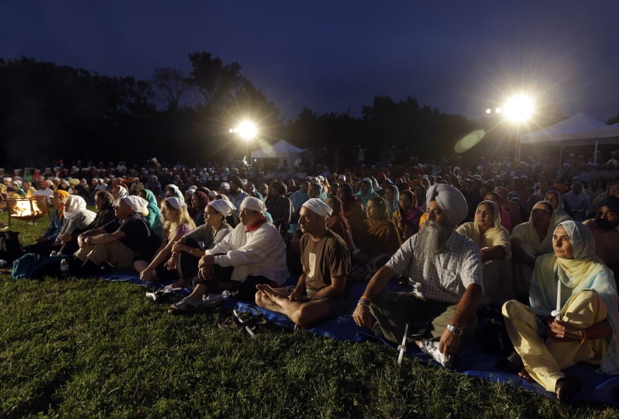 FILE - In this Aug. 5, 2013, file photo hundreds participate in a candlelight vigil at the Sikh Temple of Wisconsin to mark the one-year anniversary of the shooting rampage that left six dead in Oak Creek, Wis. The white supremacist gunman, who wounded five other worshippers and an Oak Creek police officer, killed himself in the parking lot.