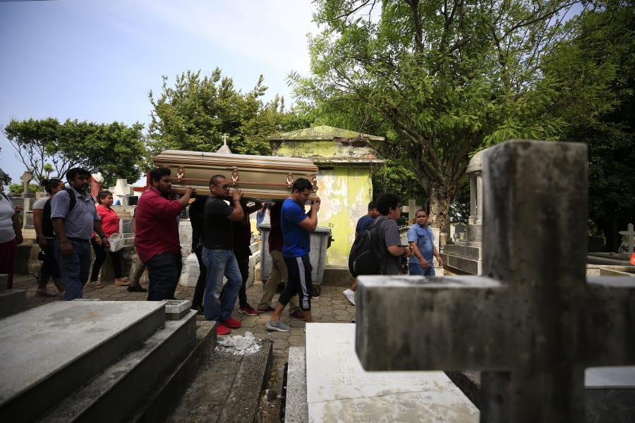 Mourners carry the coffin that contain the remains of Erick Hernandez Enriquez, also known as DJ Bengala, who was killed in an attack on the White Horse nightclub where he was DJ’ing, as they bring him for burial at the municipal cemetery in Coatzacoalcos, Veracruz state, Mexico, Thursday, Aug. 29, 2019. At least seven of the more than two dozen victims were laid to rest in the municipal cemetery Thursday afternoon, in overlapping burials two days after gang members blocked the club’s exits and set it on fire.