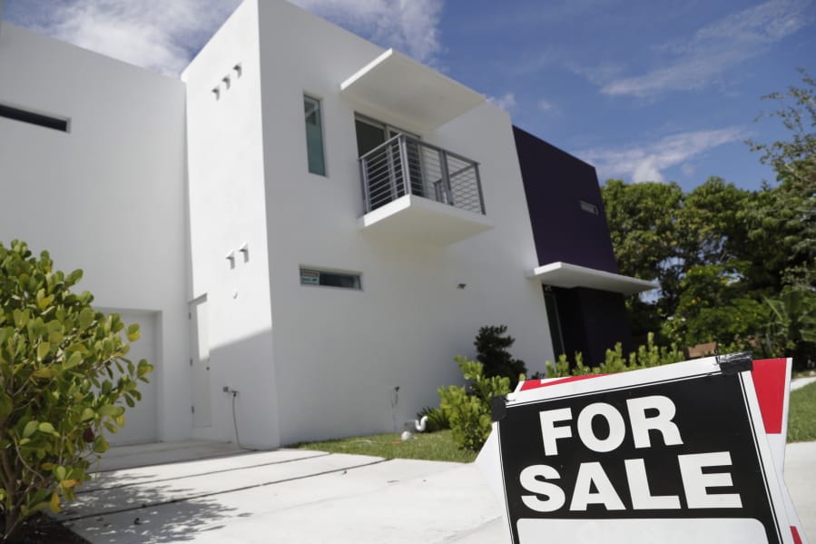 A for sale sign is posted in front of a home in Miami. A new survey has found that real estate has returned as a top option for long-term investment.