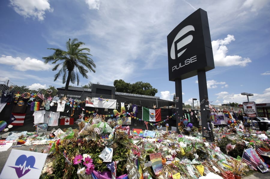 FILE - In this July 11, 2016, file photo, a makeshift memorial continues to grow outside the Pulse nightclub in Orlando, the day before the one month anniversary of a mass shooting, in Orlando, Fla. A group of survivors and family members of those killed have formed an organization to oppose the building of a private museum to honor the victims of a mass shooting at the Florida nightclub three years ago. Members of the Community Coalition Against a Pulse Museum say the nightclub should be torn down and the nightclub’s owner shouldn’t build a private museum.