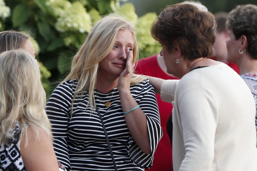 Mourners console each other after a mass in the chapel on the campus of Saint Francis University to celebrate the life of Nicholas Cumer on Tuesday, Aug. 6, 2019, in Loretto, Pa. Cumer was a graduate student in the master of cancer care program at the University and was among those killed in the Dayton shooting early Sunday.