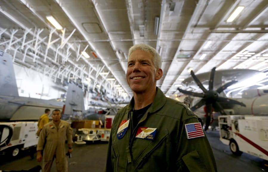 Rear Admiral Karl Thomas, Task Force 70/Commander, Carrier Strike Group 5, poses before an E-2 Hawkeye plane following a media interview aboard the U.S. aircraft carrier USS Ronald Reagan off South China Sea Tuesday, Aug. 6, 2019, west of the Philippines. The USS Ronald Reagan is cruising in international waters in the South China Sea amid tensions in the disputed islands, shoals and reefs between China and other claimant-countries as Philippines, Vietnam and Malaysia.
